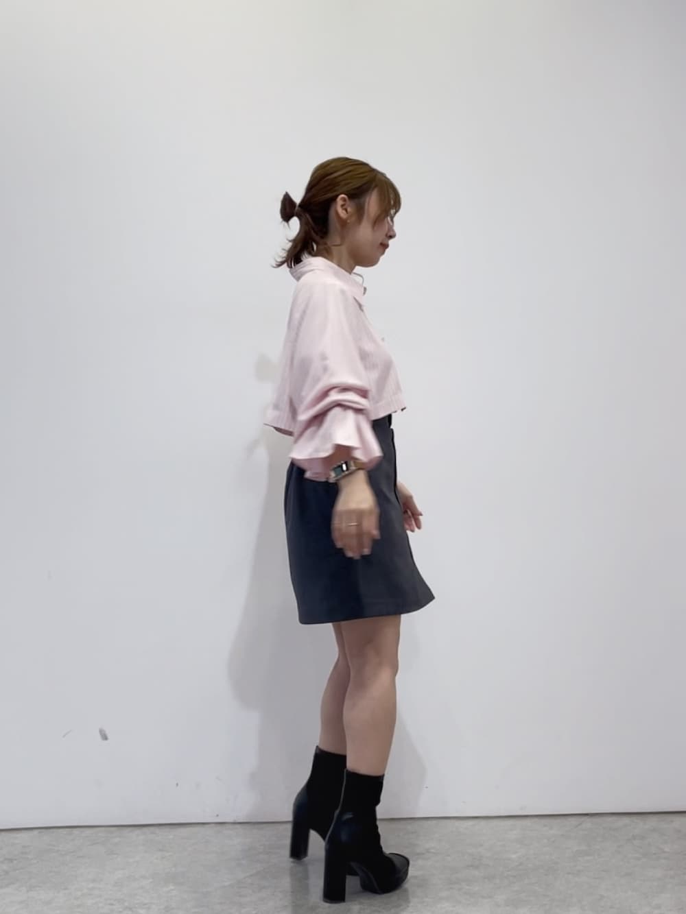 ピンク系のワンピース、グレー系のスカート、ブラック系のブーツを着用したレディースの春コーディネートの2枚目の写真
