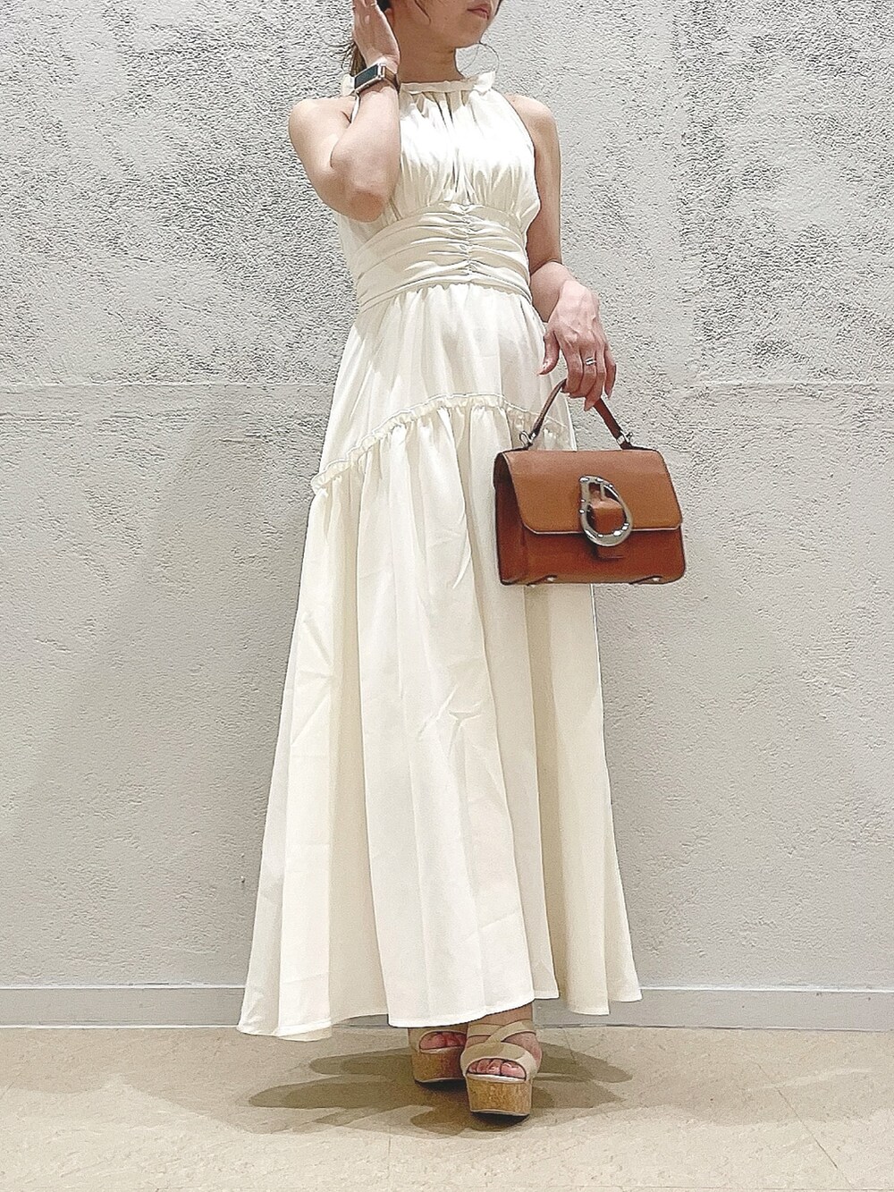 イエロー系のハンドバッグ、ホワイト系のサンダル、ホワイト系のワンピースを着用したレディースの夏コーディネートの5枚目の写真