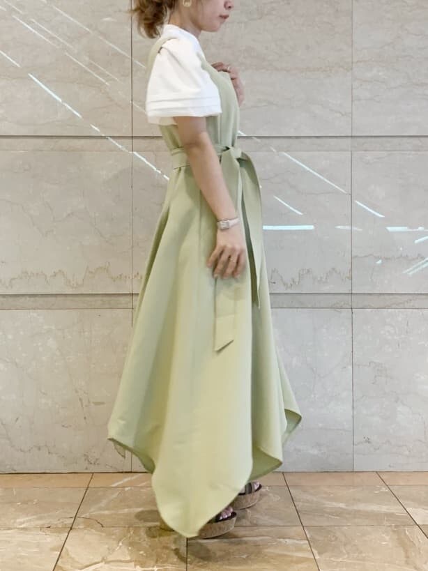 グリーン系のワンピース、ブラウン系のサンダル、ホワイト系のショルダーバッグを着用したレディースの春コーディネートの3枚目の写真