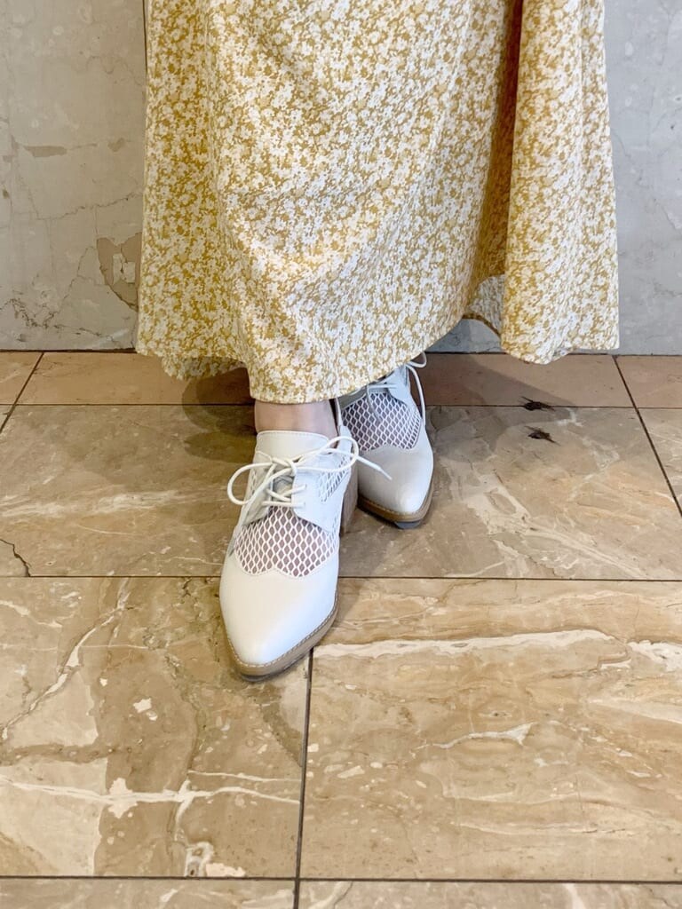 イエロー系のワンピース、ホワイト系のローファーを着用したレディースの冬コーディネートの9枚目の写真