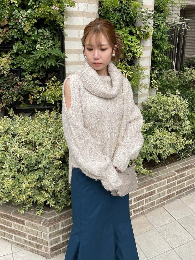 ブラック系のブーツ、ホワイト系のニット/セーター、ブルー系のスカートを着用したレディースの秋コーディネートの4枚目の写真