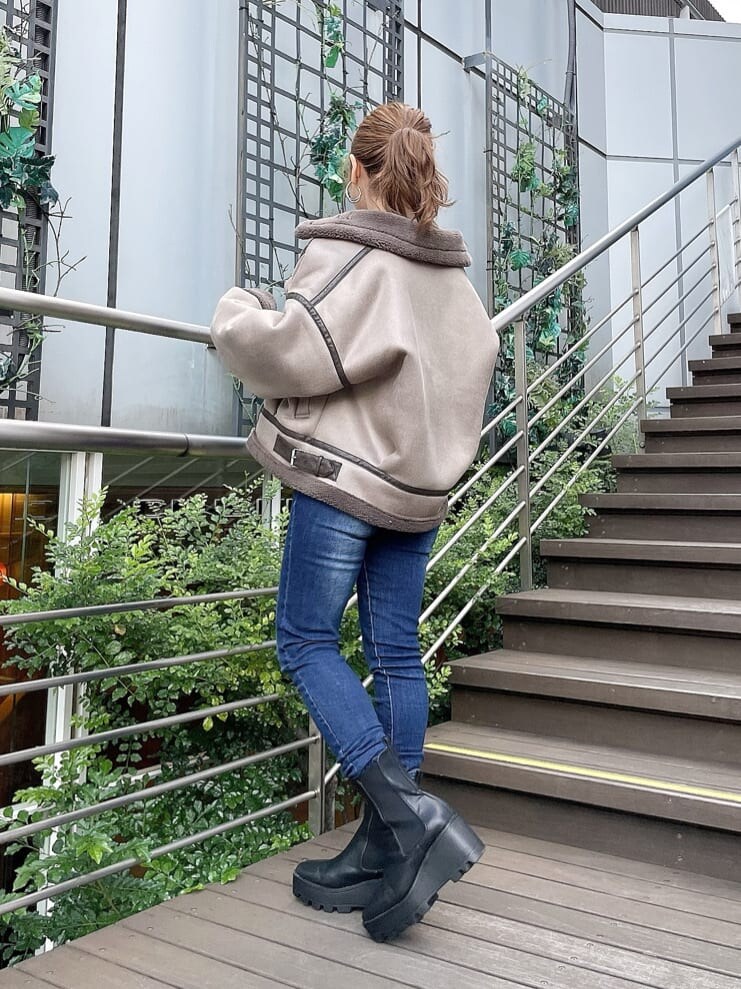 ブルー系のデニムパンツ、ホワイト系のニット/セーター、ブルー系のデニムパンツを着用したレディースの秋コーディネートの2枚目の写真