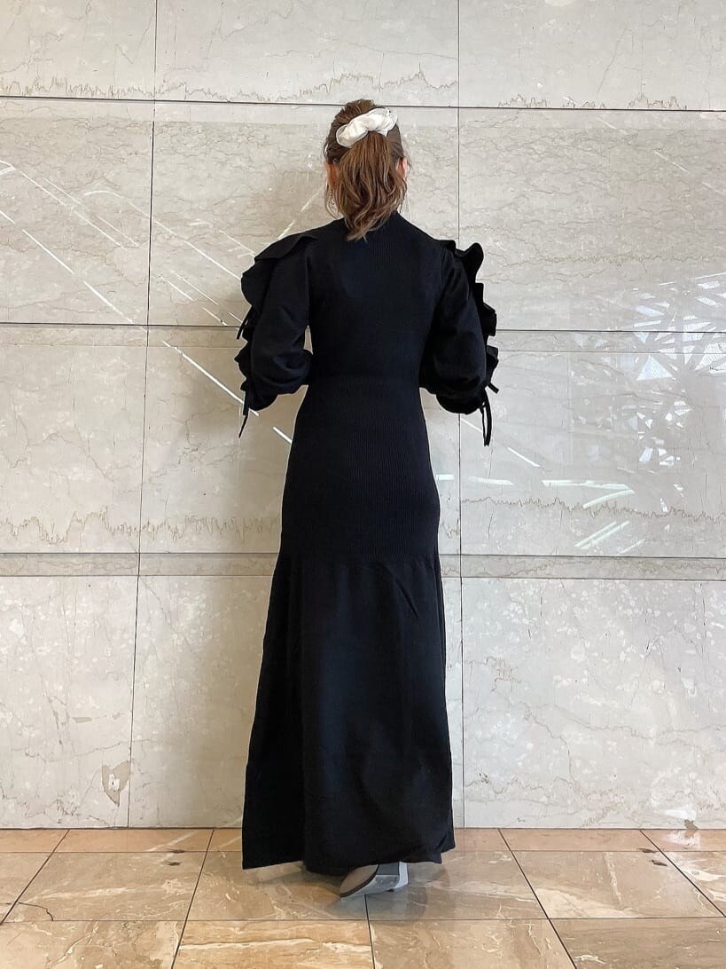 ベージュ系のブーツ、ブラック系のワンピース、ゴールド系のピアス（両耳用）を着用したレディースの秋コーディネートの3枚目の写真