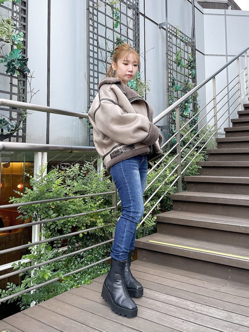 ブルー系のデニムパンツ、ホワイト系のニット/セーター、ブルー系のデニムパンツを着用したレディースの秋コーディネートの4枚目の写真