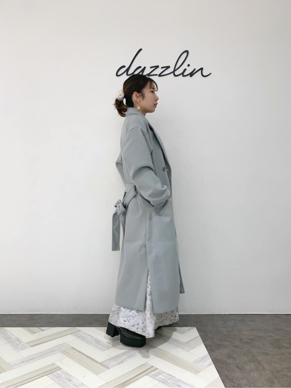 グレー系のブーツ、ブルー系のチェスターコート、グレー系のワンピースを着用したレディースの冬コーディネートの4枚目の写真