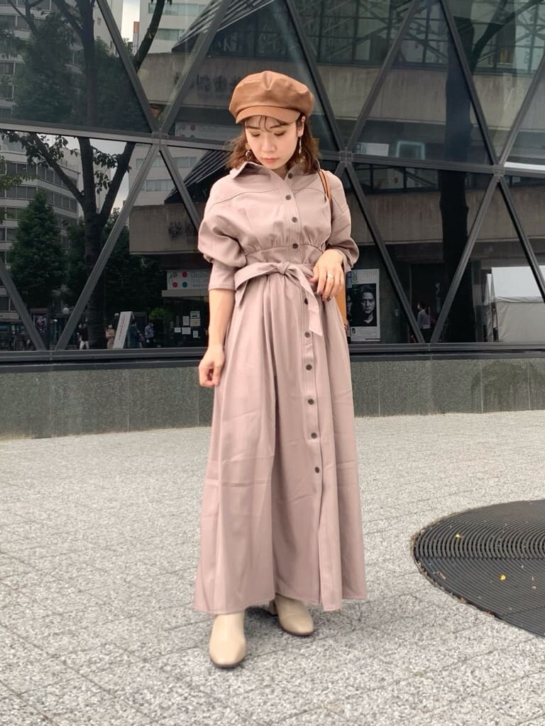 ベージュ系のワンピース、ブラウン系のバックパック/リュック、ベージュ系のブーツを着用したレディースの夏コーディネートの2枚目の写真