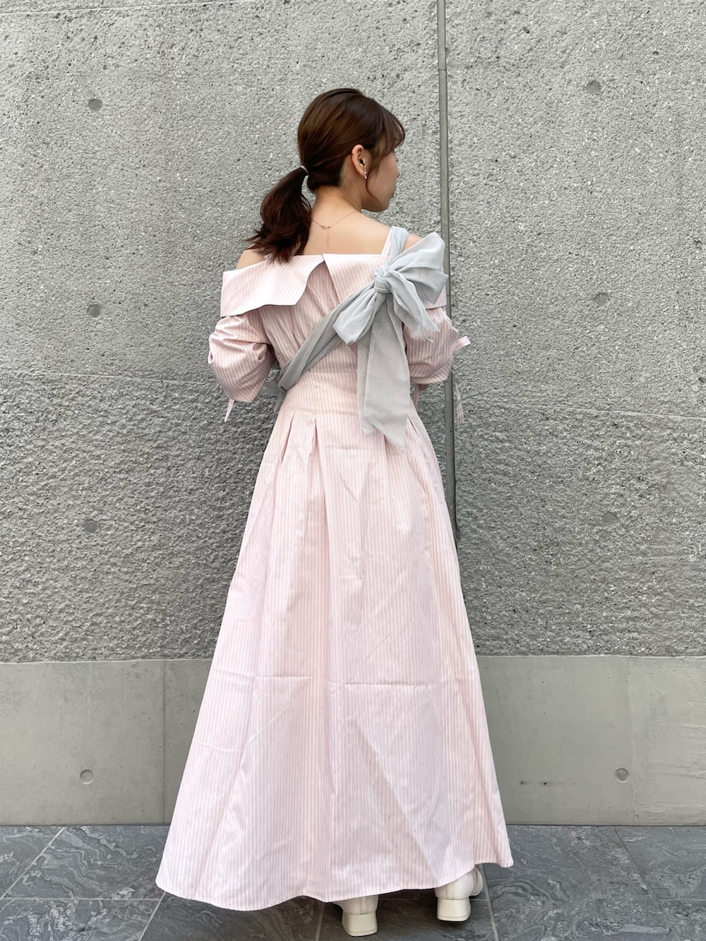 ピンク系のシャツワンピース、グレー系のベスト、ホワイト系のパンプスを着用したレディースの春コーディネートの4枚目の写真