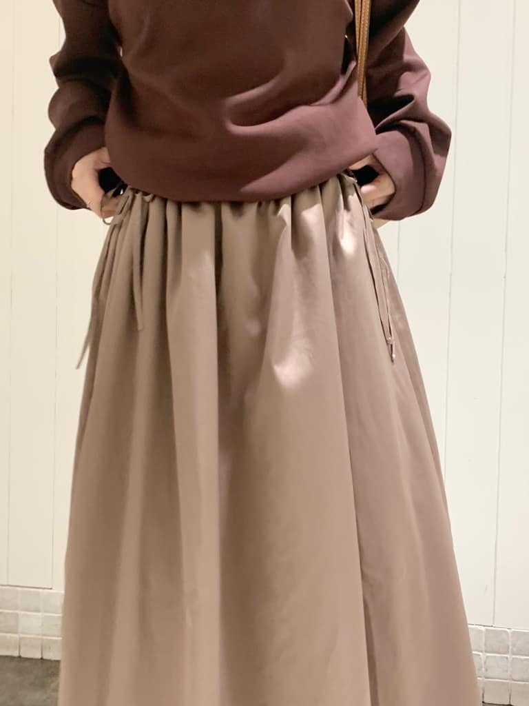 ベージュ系のワンピース、ブラック系のバックパック/リュック、ベージュ系のブーツを着用したレディースの秋コーディネートの7枚目の写真