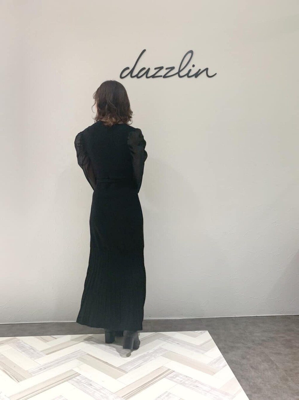 ブラック系のブルゾン、ブラック系のワンピース、ブラック系のブーツを着用したレディースの秋コーディネートの6枚目の写真