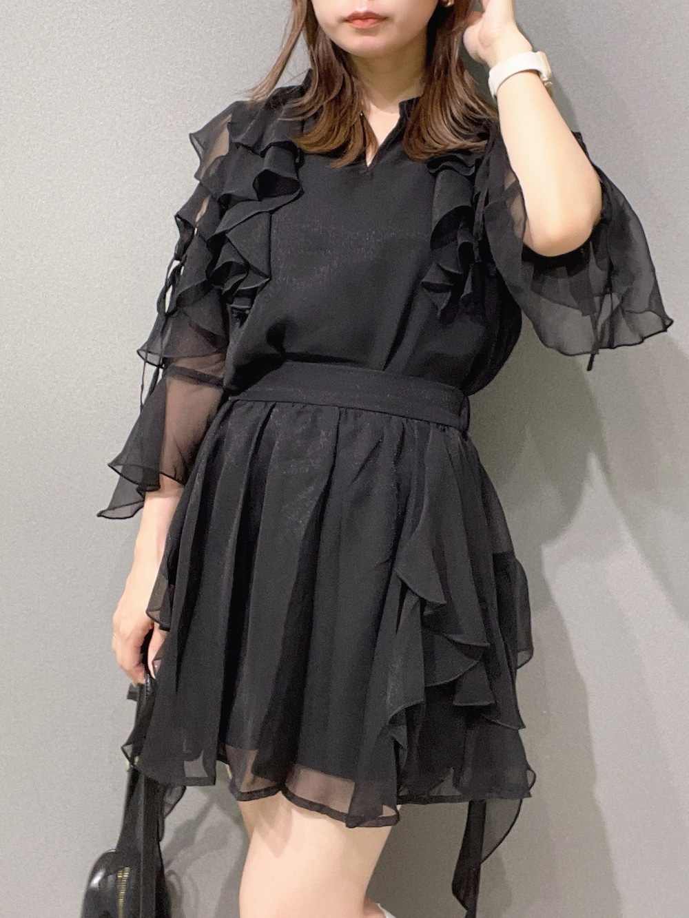 ブラック系のシャツ/ブラウス、ブラック系のスカート、ホワイト系のサンダルを着用したレディースの夏コーディネートの5枚目の写真