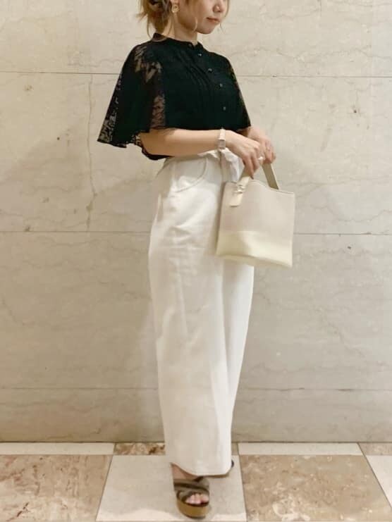 ブラック系のシャツ/ブラウス、ホワイト系のハンドバッグ、ブラウン系のサンダルを着用したレディースの春コーディネートの2枚目の写真