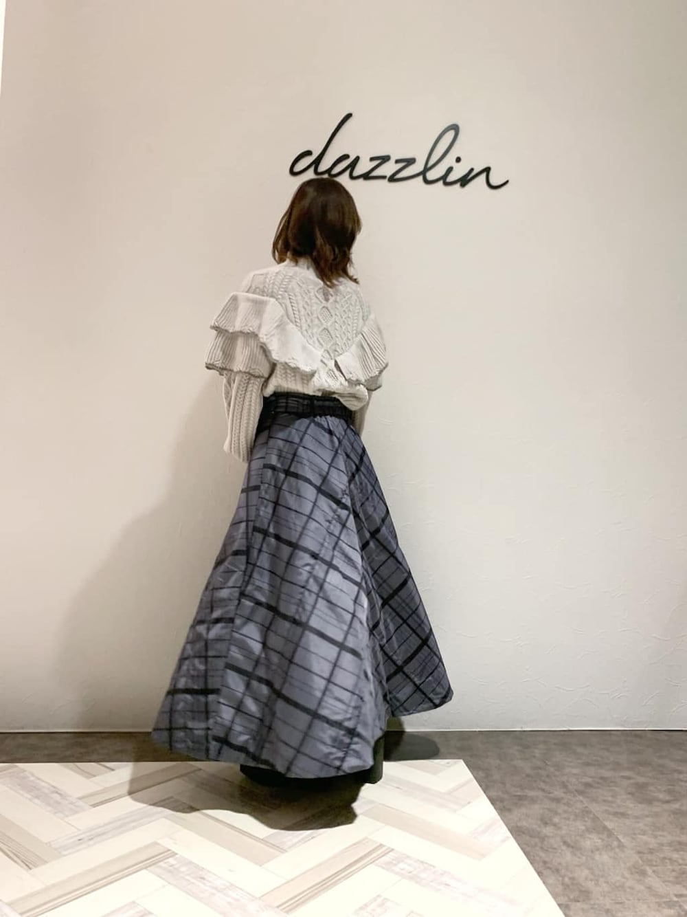 ブラック系のハンドバッグ、グレー系のスカート、グレー系のブーツを着用したレディースの秋コーディネートの3枚目の写真