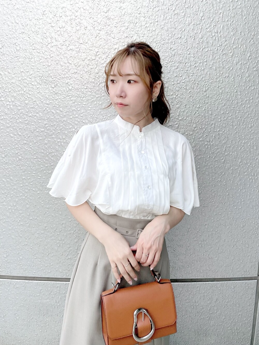 ホワイト系のシャツ/ブラウス、グリーン系のスカート、ホワイト系のパンプスを着用したレディースの春コーディネートの6枚目の写真