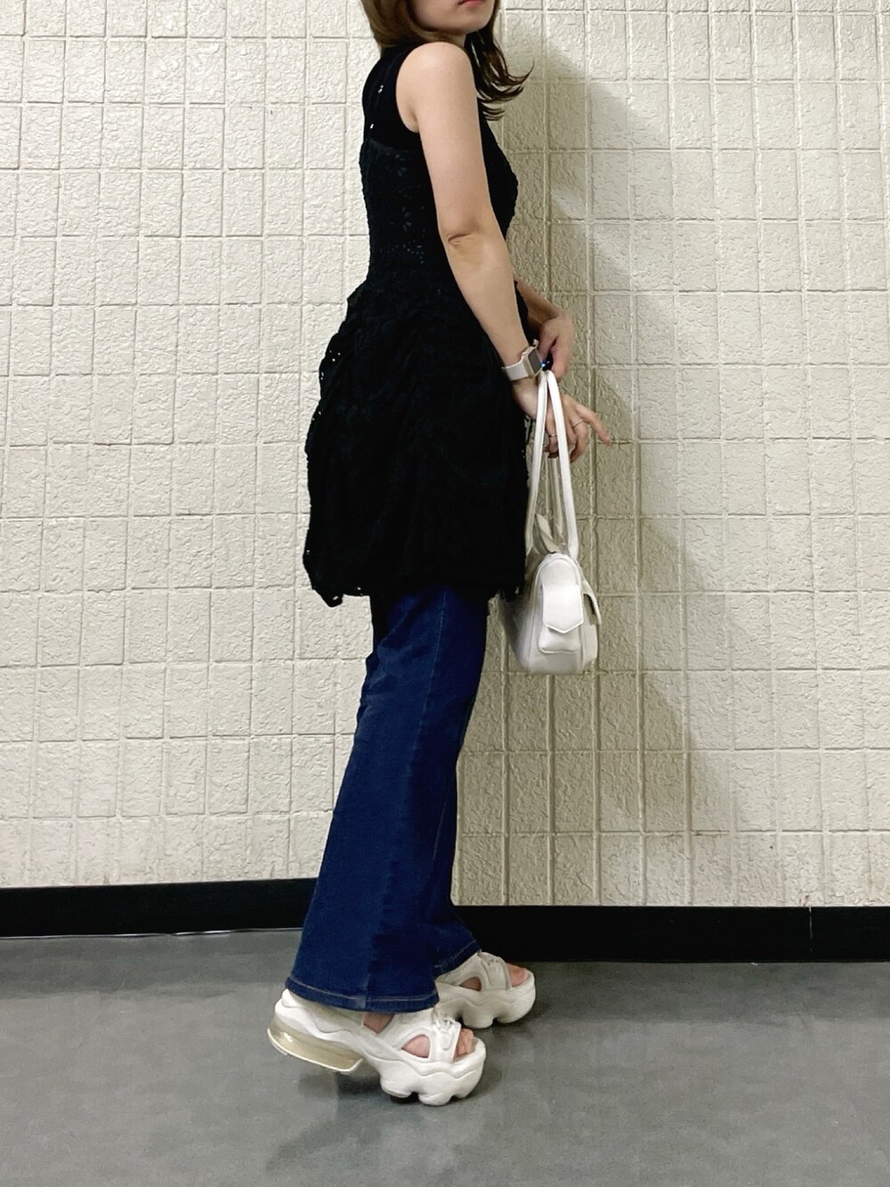 ブラック系のワンピース、ブラック系のニット/セーター、ホワイト系のボストンバッグを着用したレディースの春コーディネートの5枚目の写真