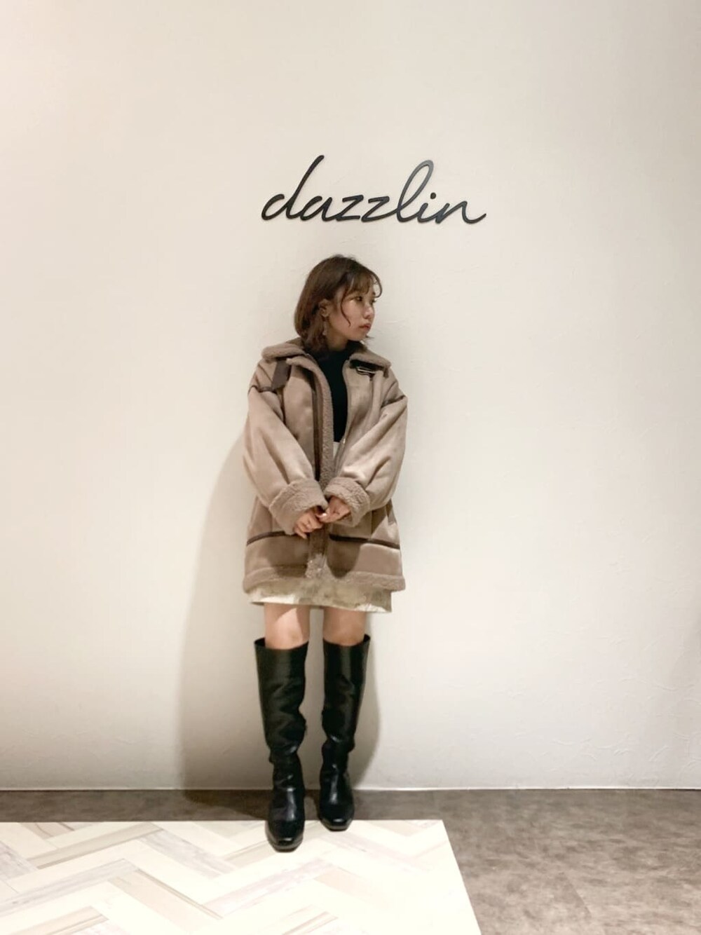 ベージュ系のブルゾン、ベージュ系のスカート、ブラック系のブーツを着用したレディースの秋コーディネートの7枚目の写真