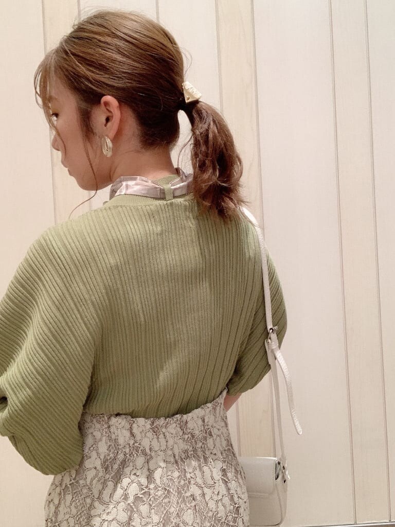 ベージュ系のスカート、ホワイト系のパンプス、グリーン系のニット/セーターを着用したレディースの春コーディネートの6枚目の写真