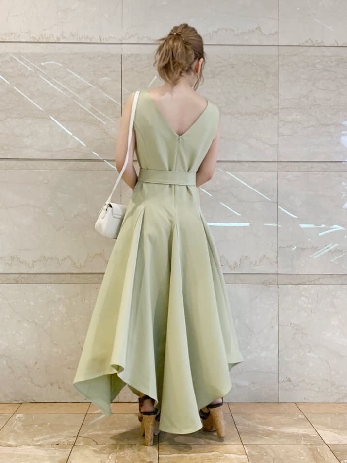 グリーン系のワンピース、ブラウン系のサンダル、ホワイト系のシャツ/ブラウスを着用したレディースの春コーディネートの3枚目の写真