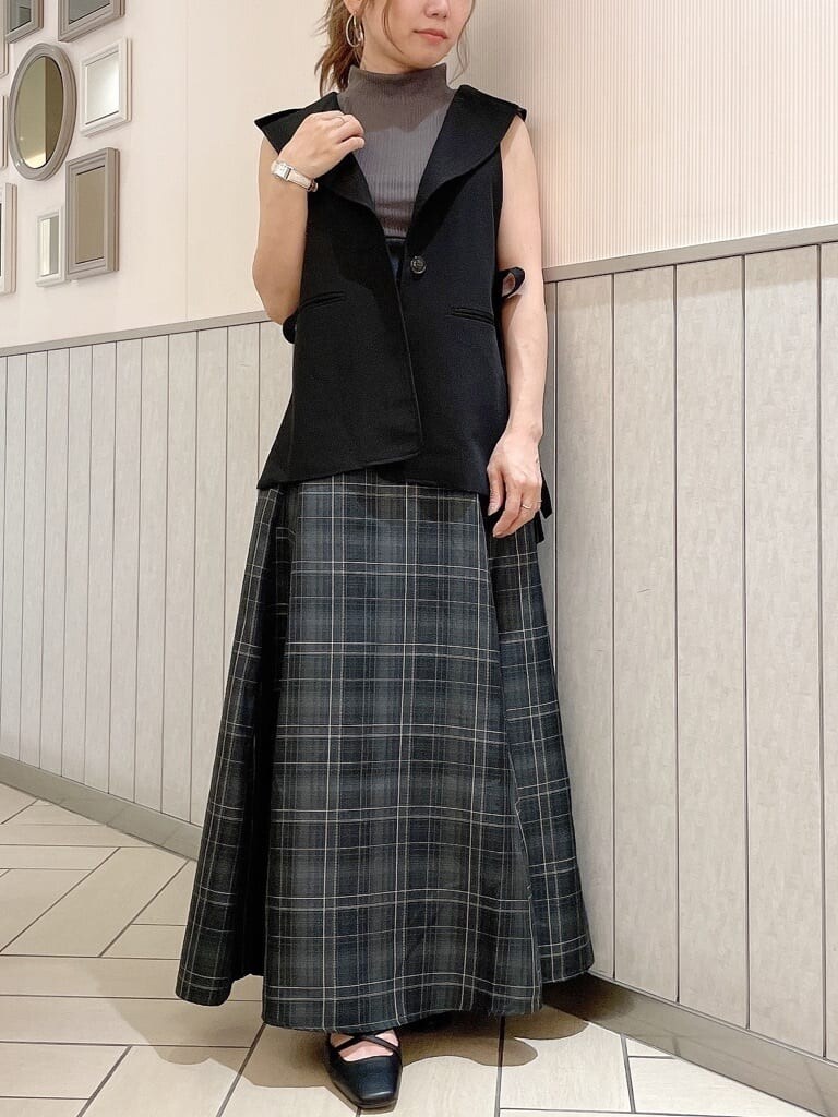 ブラック系のベスト、グレー系のワンピース、ブラック系のパンプスを着用したレディースの夏コーディネートの2枚目の写真