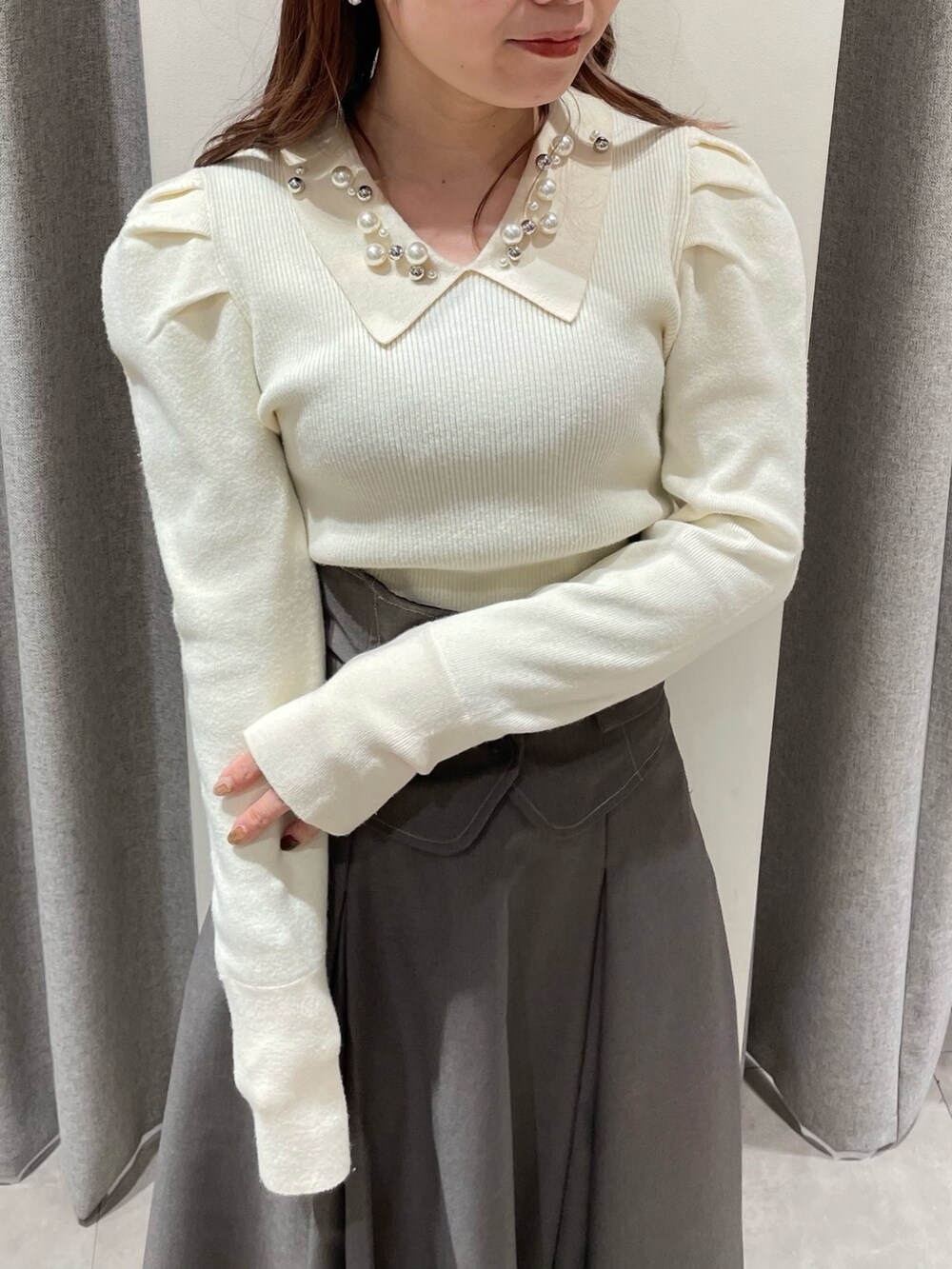 ホワイト系のニット/セーター、グレー系のスカート、ベージュ系のブーツを着用したレディースの冬コーディネートの5枚目の写真