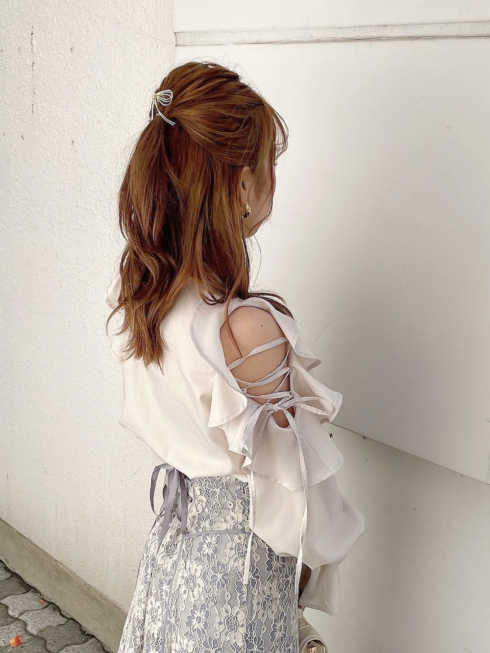 ベージュ系のシャツ/ブラウス、ブルー系のスカート、ホワイト系のパンプスを着用したレディースの冬コーディネートの6枚目の写真