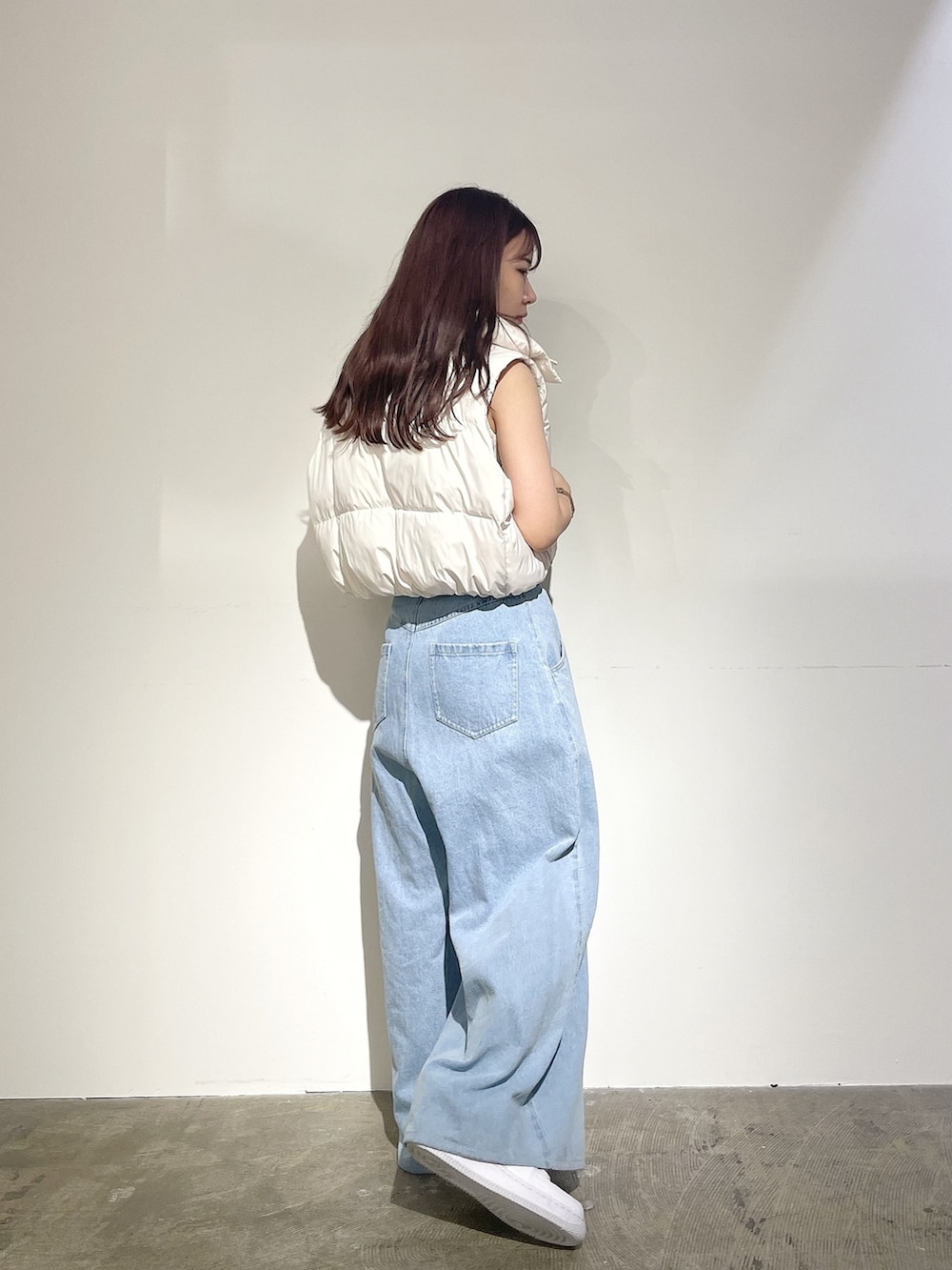ブルー系のデニムパンツ、ホワイト系のニット/セーター、ホワイト系のベストを着用したレディースの夏コーディネートの2枚目の写真