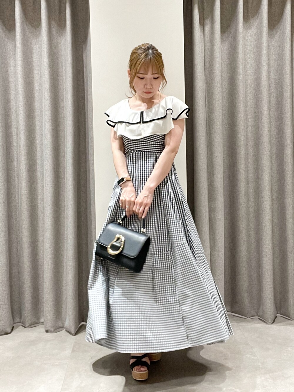 その他のワンピース、ブラック系のニット/セーター、ブラック系のハンドバッグを着用したレディースの夏コーディネートの2枚目の写真