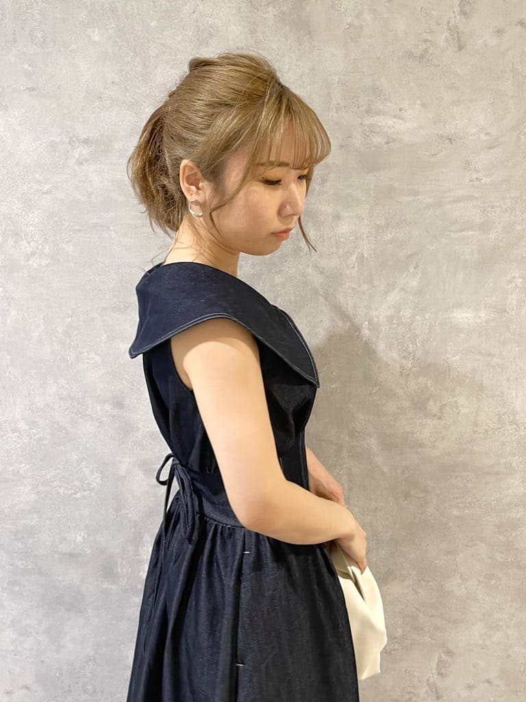 ホワイト系のハンドバッグ、ホワイト系のサンダル、ブルー系のワンピースを着用したレディースの夏コーディネートの6枚目の写真