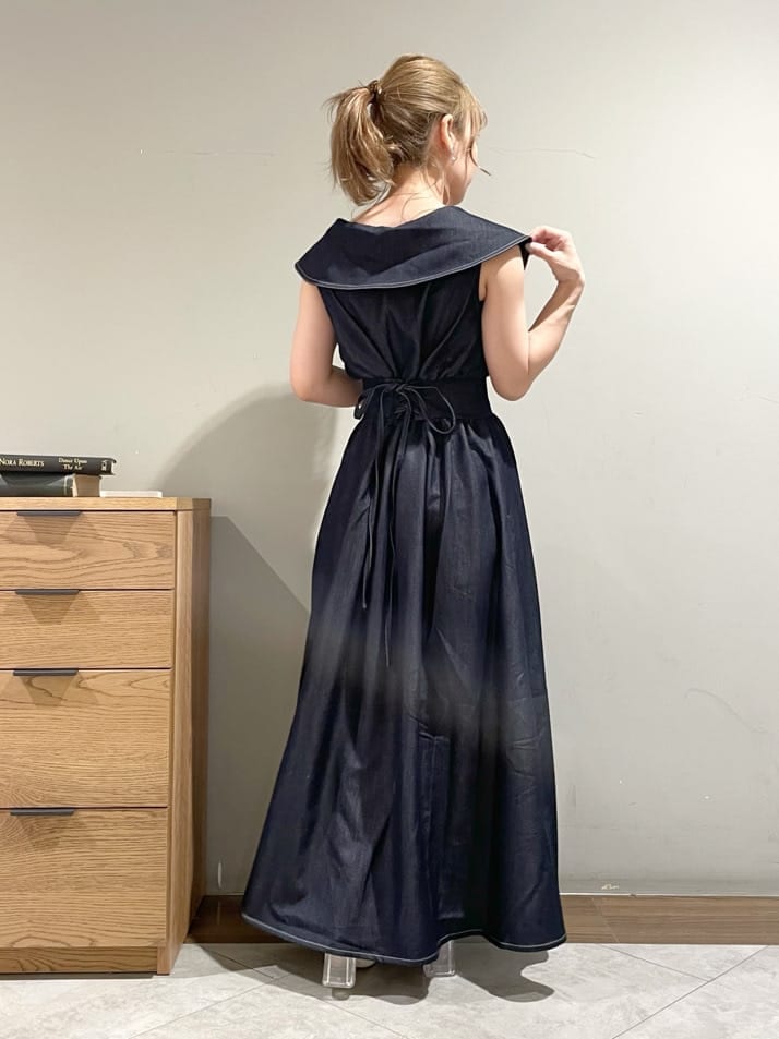 ホワイト系のハンドバッグ、ホワイト系のサンダル、ブルー系のワンピースを着用したレディースの夏コーディネートの2枚目の写真