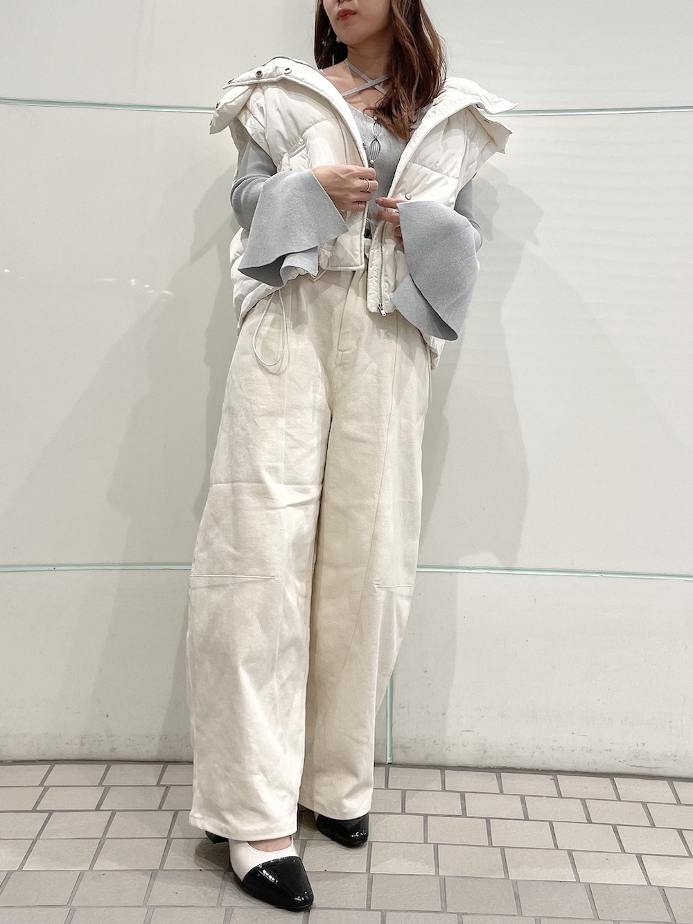 グレー系のニット/セーター、ホワイト系のダウンジャケット/コート、ホワイト系のデニムパンツを着用したレディースの冬コーディネートの6枚目の写真