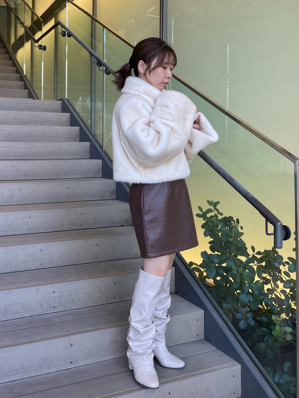 ホワイト系のその他アウター、ブラウン系のスカート、ベージュ系のブーツを着用したレディースの秋コーディネートの2枚目の写真