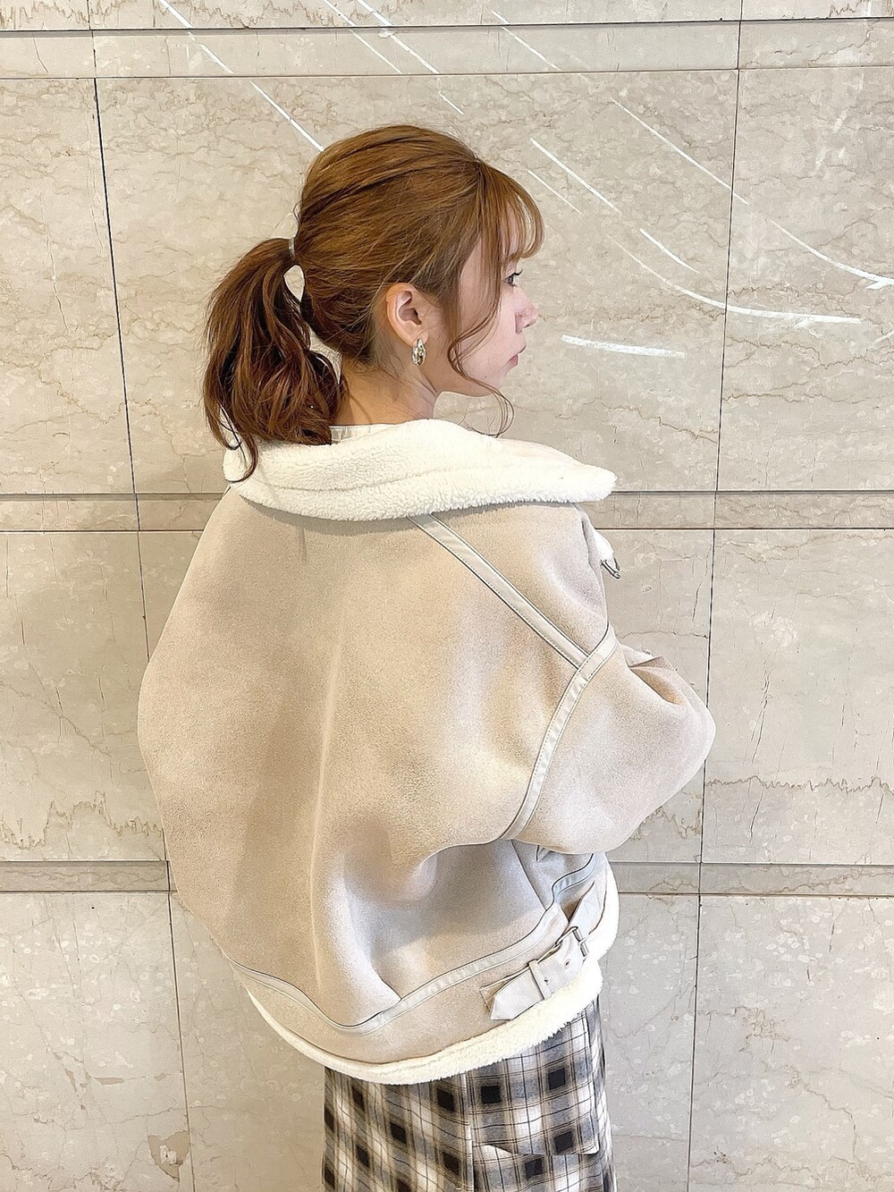 ホワイト系のブルゾン、イエロー系のワンピース、グレー系のパンプスを着用したレディースの冬コーディネートの5枚目の写真