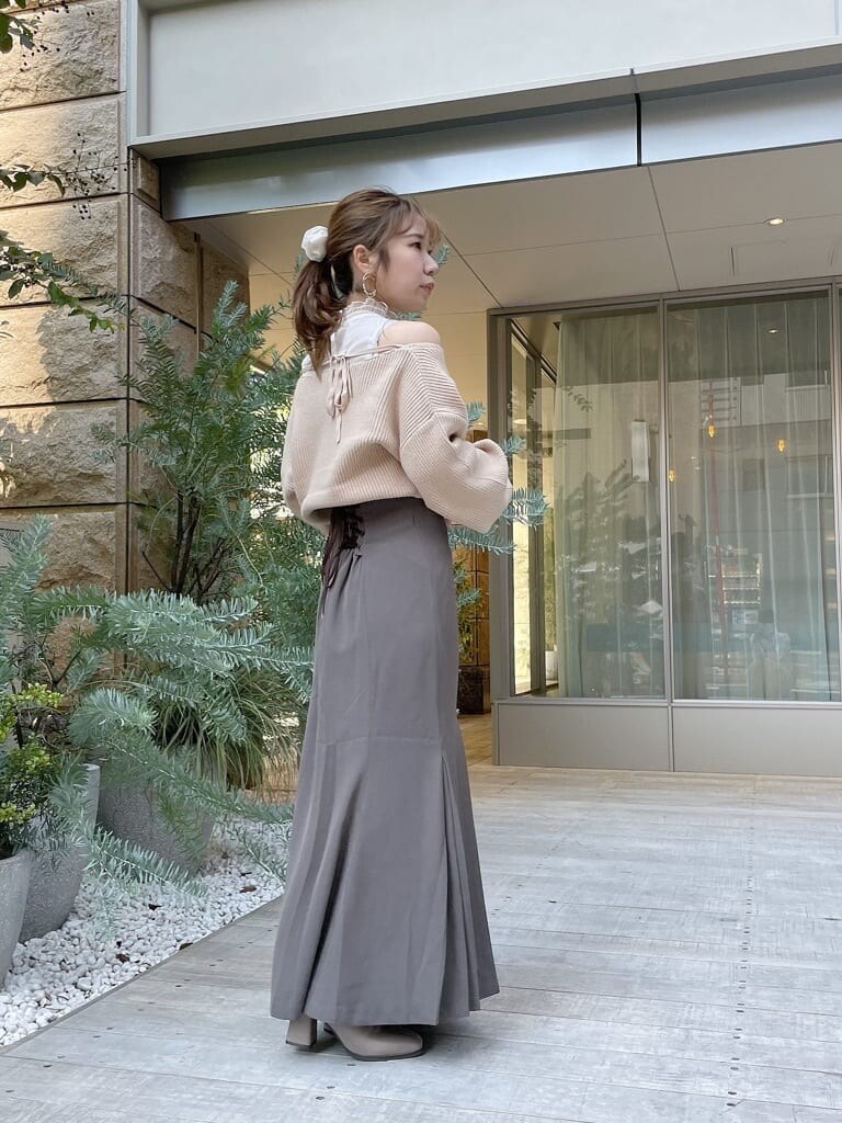 ベージュ系のニット/セーター、ベージュ系のスカート、ベージュ系のブーツを着用したレディースの秋コーディネートの3枚目の写真