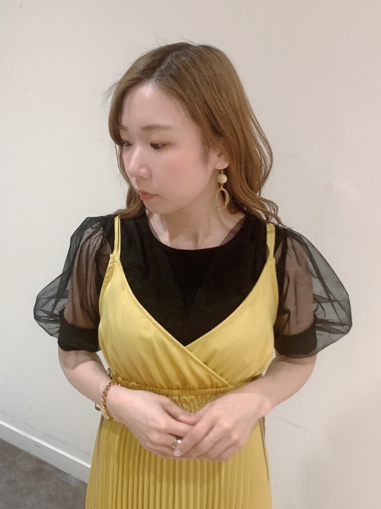 イエロー系のワンピース、ブラック系のパンプス、ブラック系のニット/セーターを着用したレディースの春コーディネートの5枚目の写真