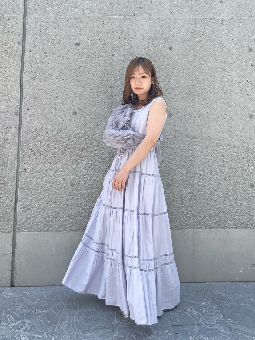 パープル系のベスト、パープル系のワンピース、シルバー系のパンプスを着用したレディースの夏コーディネートの3枚目の写真