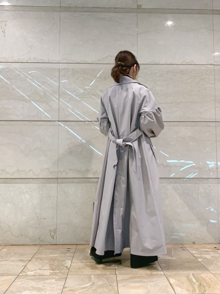 グレー系のトレンチコート、ブラック系のその他パンツ、ブラック系のローファーを着用したレディースの冬コーディネートの4枚目の写真