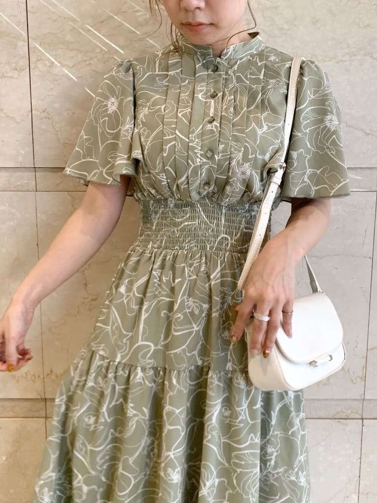 グリーン系のワンピース、ベージュ系のサンダル、ホワイト系のショルダーバッグを着用したレディースの春コーディネートの6枚目の写真
