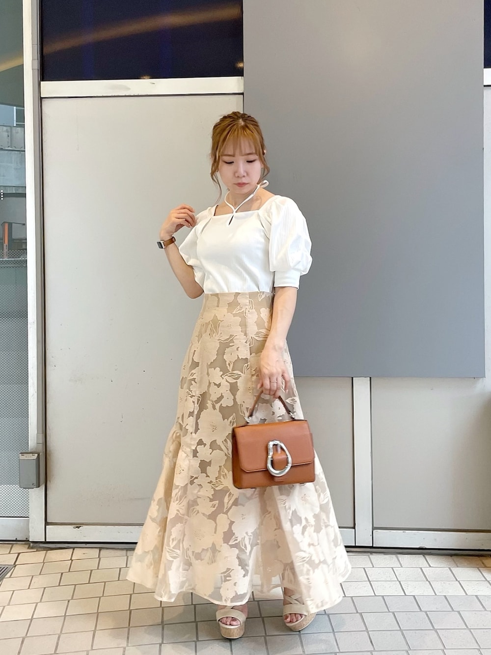 ホワイト系のサンダル、イエロー系のハンドバッグ、ホワイト系のTシャツ/カットソーを着用したレディースの夏コーディネートの2枚目の写真