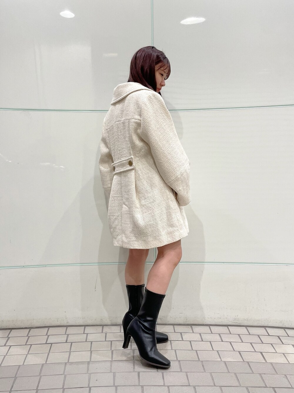 ピンク系のニット/セーター、グレー系のスカート、ホワイト系のその他アウターを着用したレディースの秋コーディネートの6枚目の写真