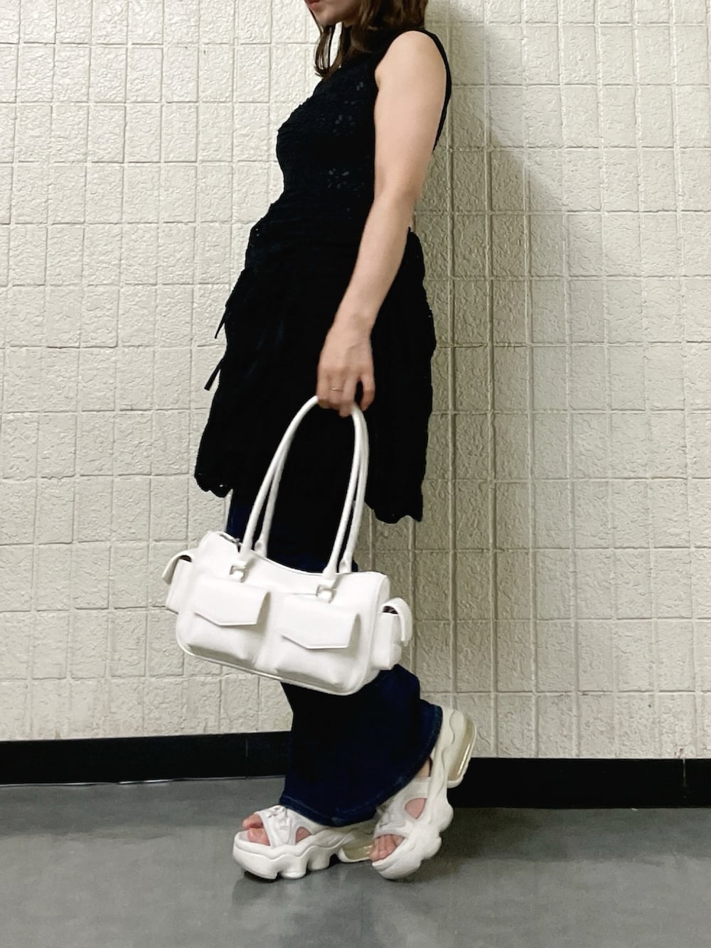 ブラック系のワンピース、ブラック系のニット/セーター、ホワイト系のボストンバッグを着用したレディースの春コーディネートの2枚目の写真