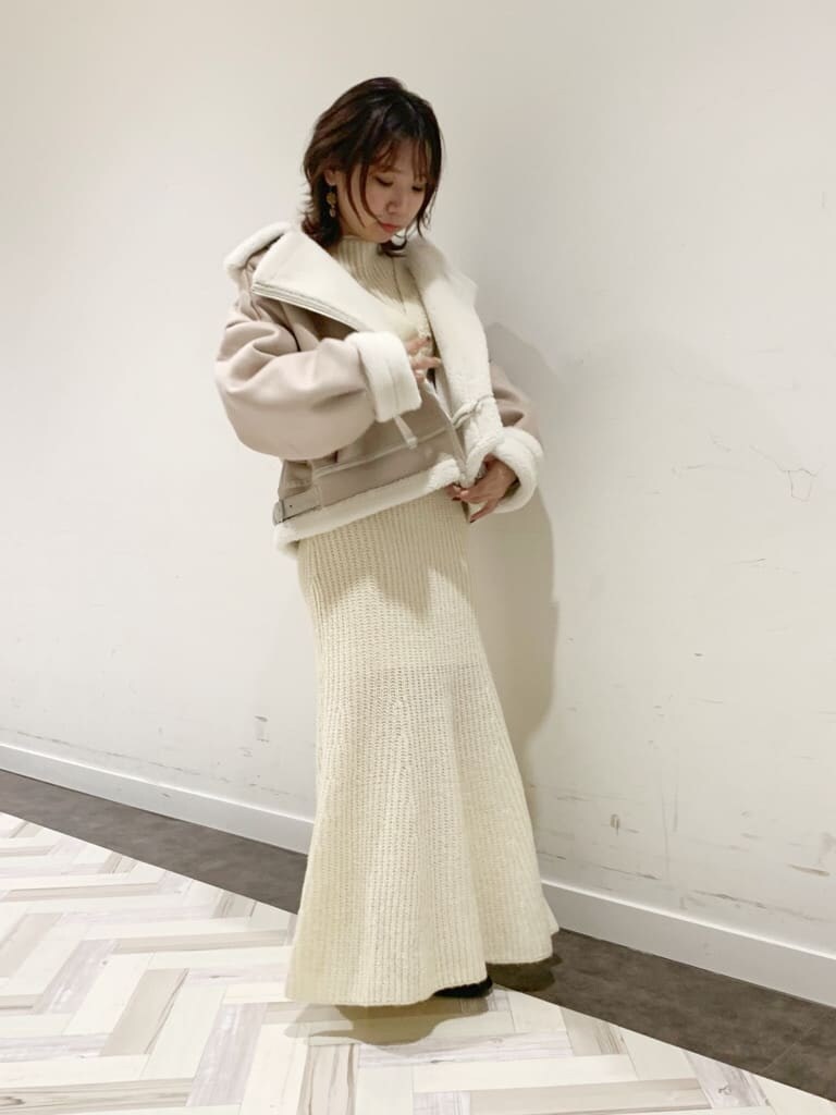 ホワイト系のワンピース、ホワイト系のブルゾン、ブラック系のブーツを着用したレディースの秋コーディネートの7枚目の写真