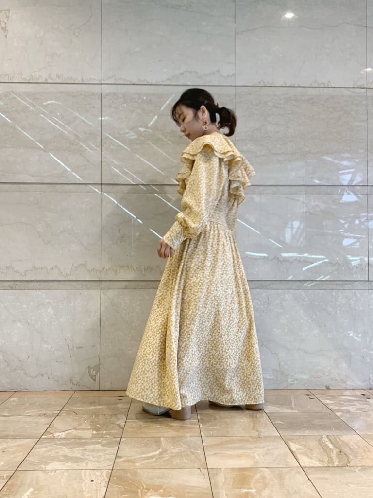 イエロー系のワンピース、ホワイト系のローファーを着用したレディースの冬コーディネートの5枚目の写真