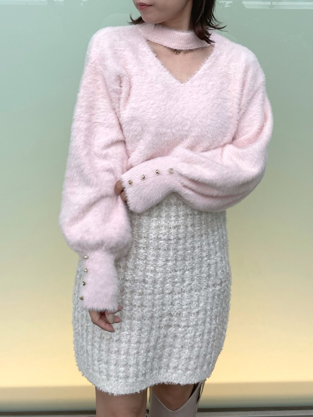 ピンク系のニット/セーター、ホワイト系のスカート、ベージュ系のブーツを着用したレディースの秋コーディネートの6枚目の写真