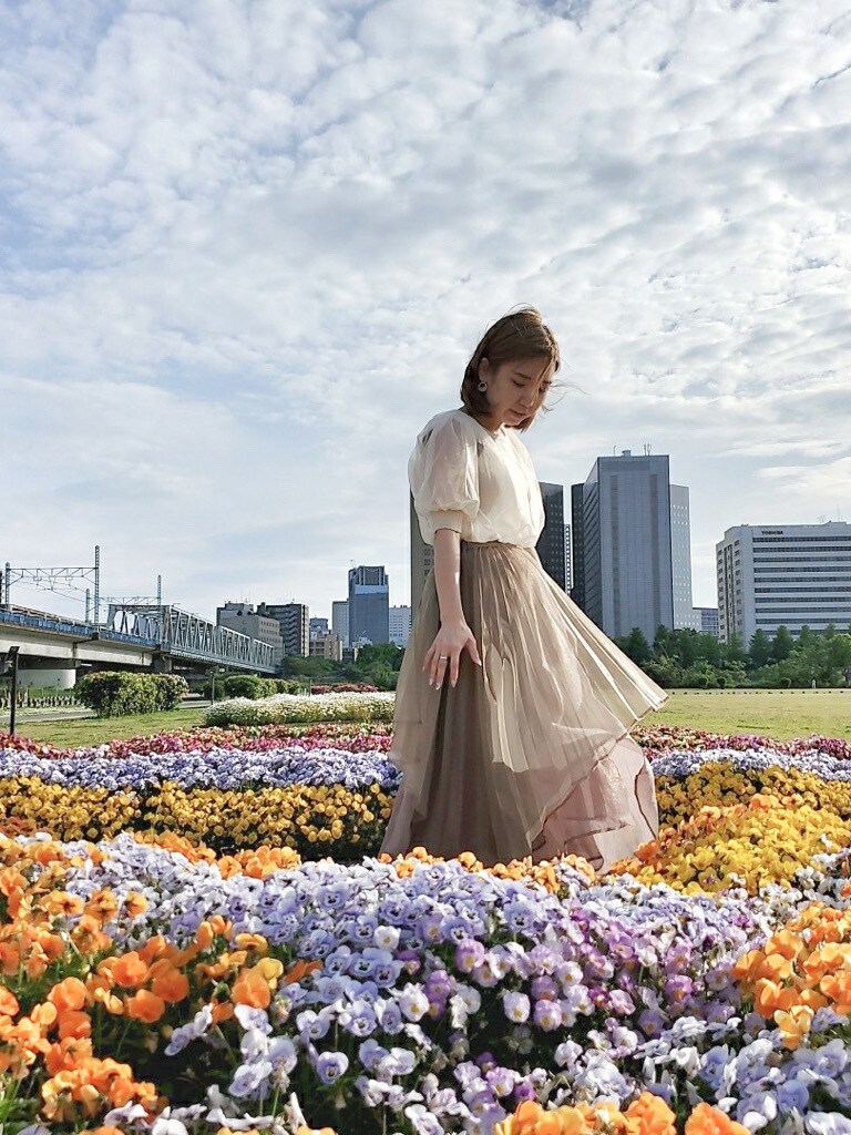 ブラウン系のスカート、ホワイト系のパンプス、ホワイト系のニット/セーターを着用したレディースの春コーディネートの2枚目の写真