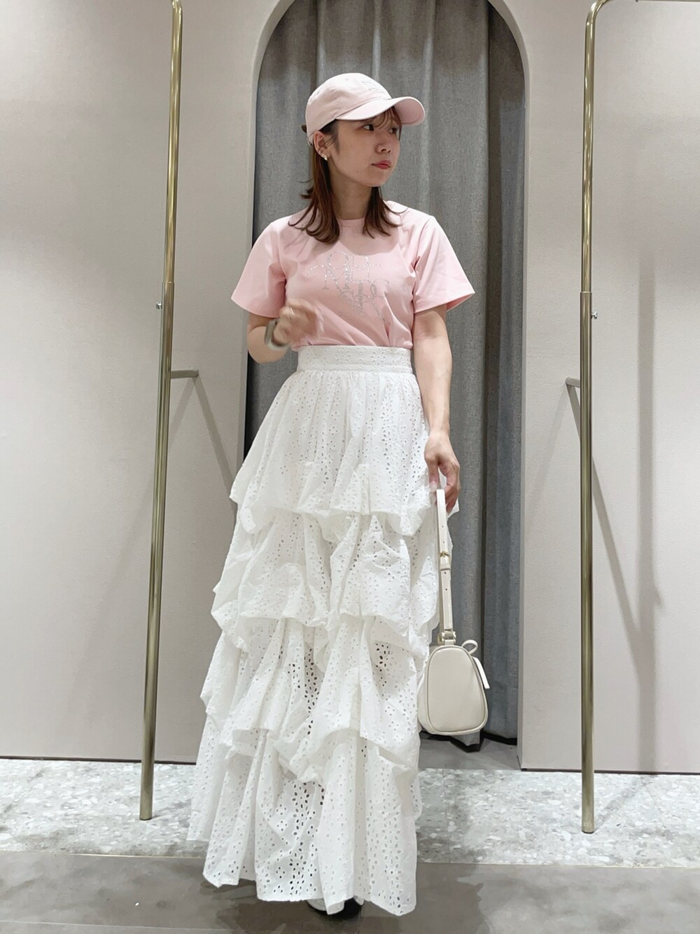 ピンク系のTシャツ/カットソー、ホワイト系のスカート、ホワイト系のサンダルを着用したレディースの夏コーディネートの3枚目の写真