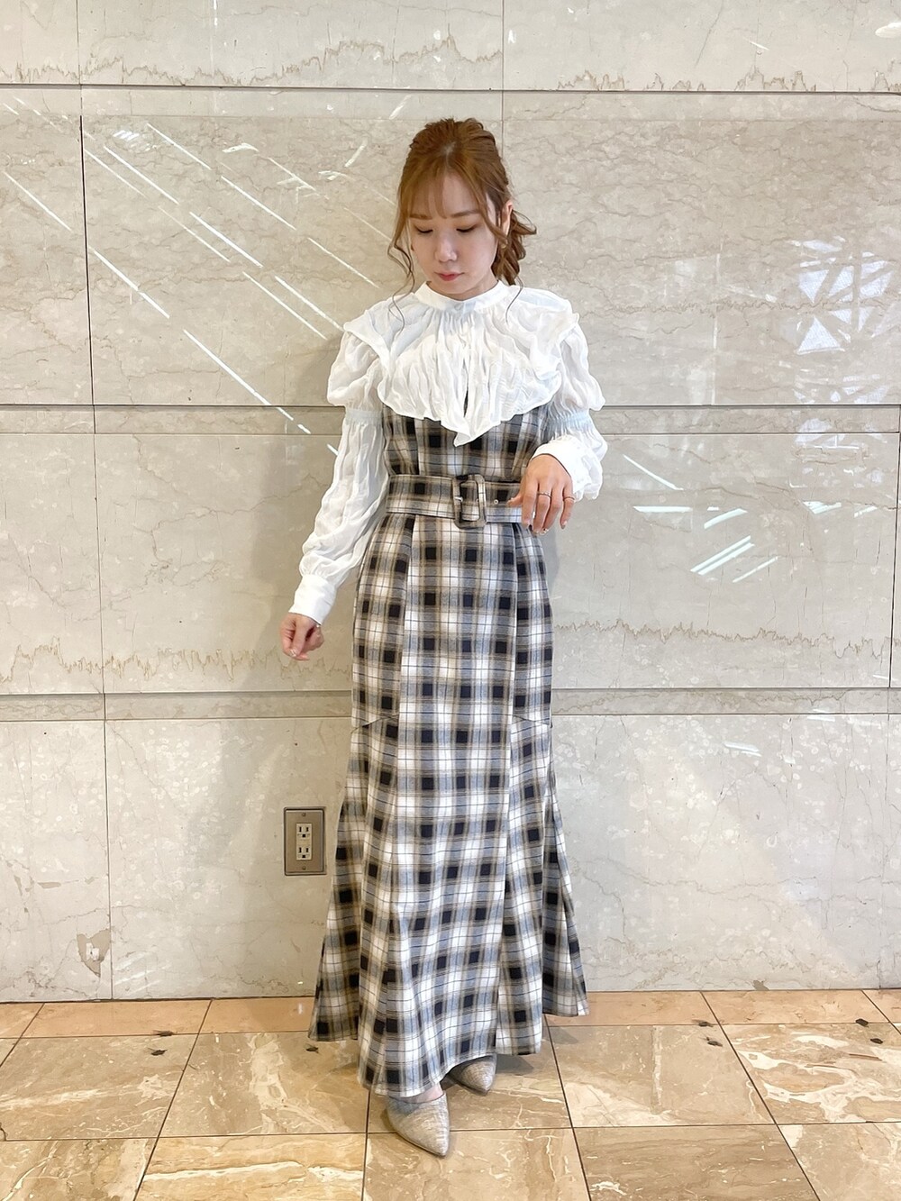 イエロー系のワンピース、グレー系のパンプスを着用したレディースの冬コーディネートの4枚目の写真