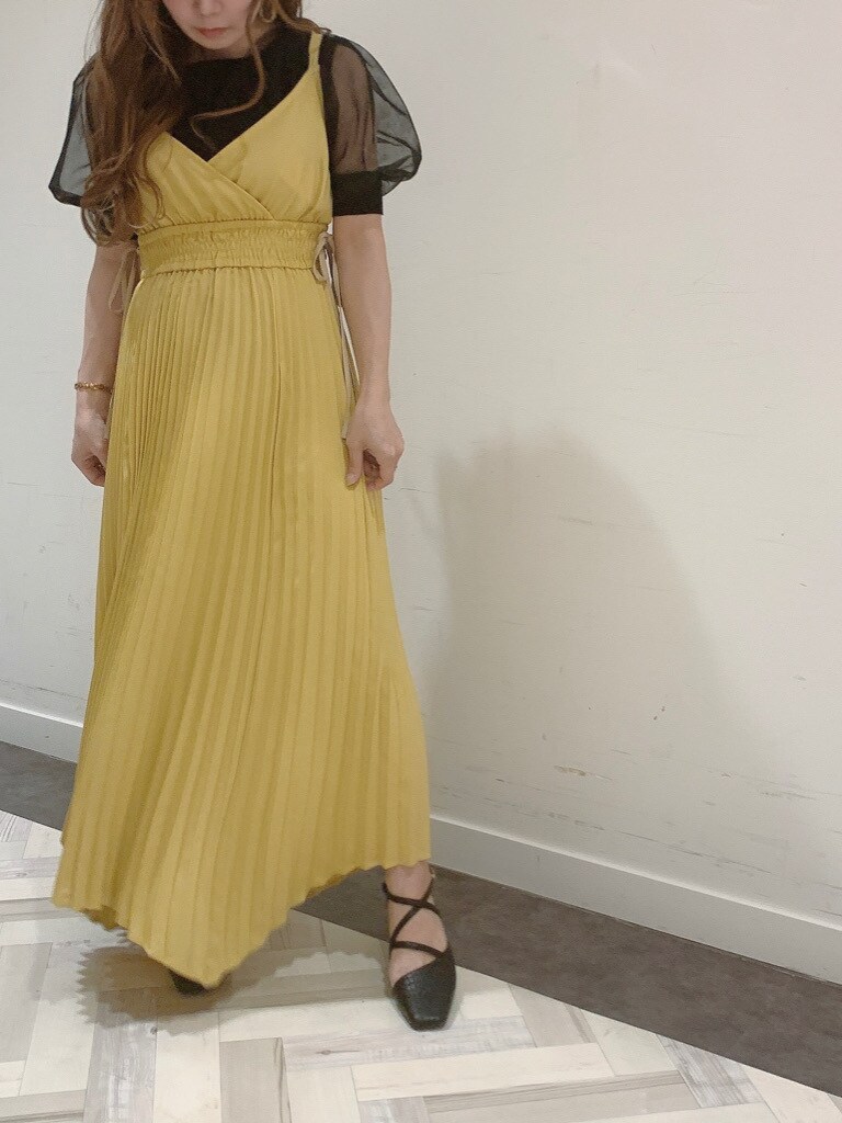 イエロー系のワンピース、ブラック系のパンプス、ブラック系のニット/セーターを着用したレディースの春コーディネートの2枚目の写真