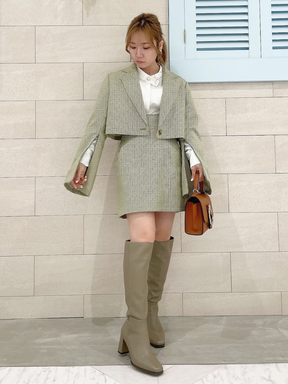 グリーン系のテーラードジャケット、ホワイト系のシャツ/ブラウス、グリーン系のスカートを着用したレディースの冬コーディネートの3枚目の写真