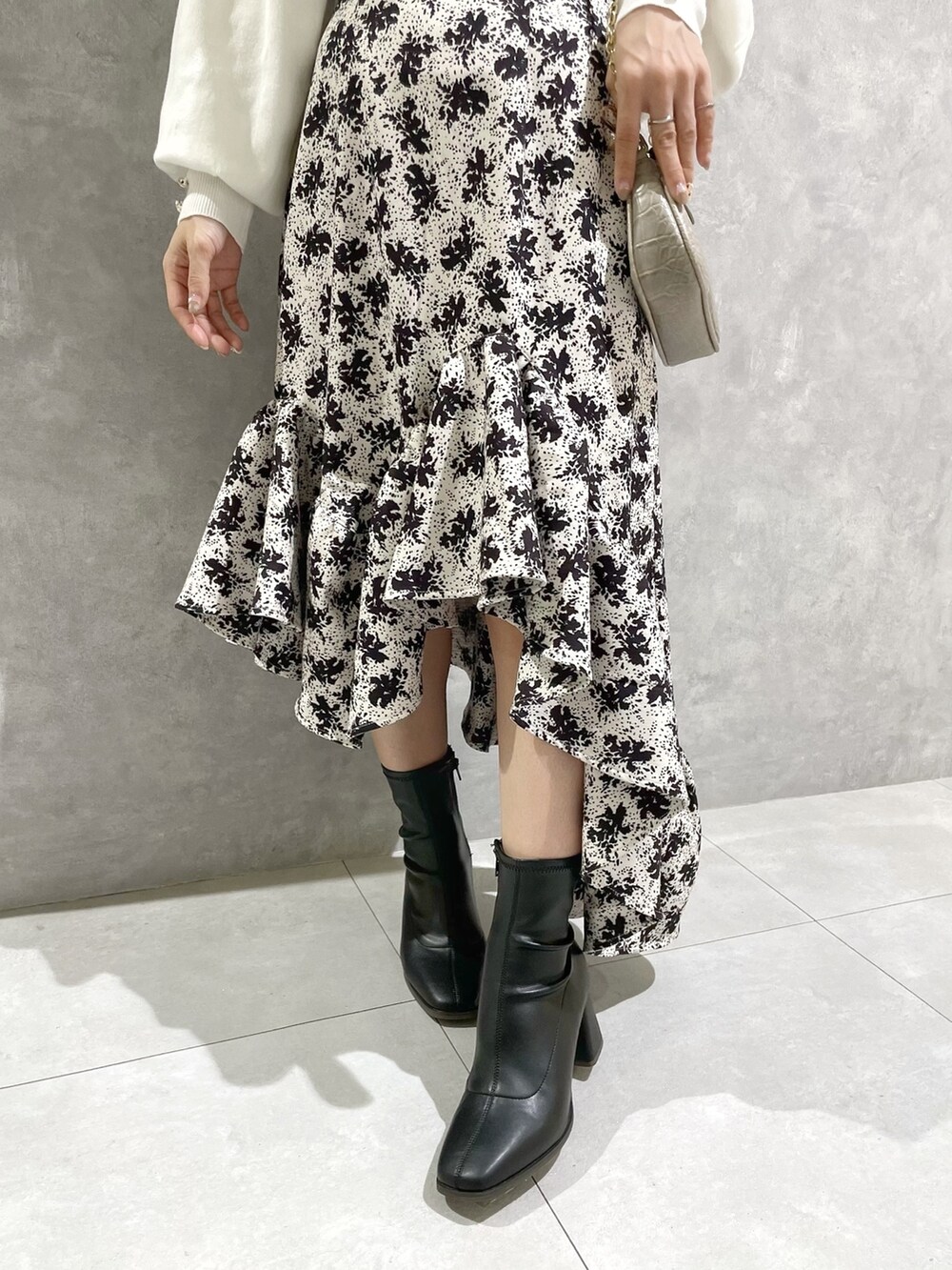 ホワイト系のニット/セーター、その他のスカート、ブラック系のブーツを着用したレディースの秋コーディネートの8枚目の写真