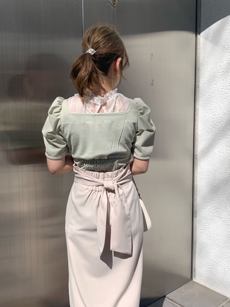 ベージュ系のスカート、グリーン系のTシャツ/カットソー、ホワイト系のサンダルを着用したレディースの春コーディネートの5枚目の写真