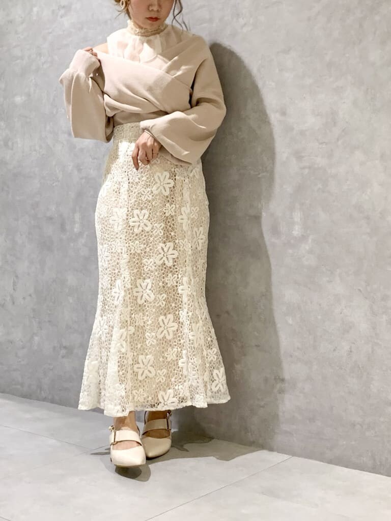 ホワイト系のスカート、ホワイト系のパンプス、ホワイト系のショルダーバッグを着用したレディースの春コーディネートの4枚目の写真